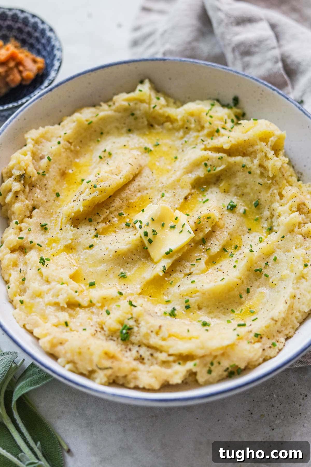 Umami Miso Mashed Potatoes Recipe 6 Closeup shot of miso mashed potatoes with sage, chives, and butter in a bowl.