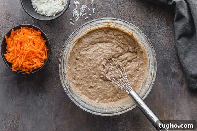 Dairy-Free, Eggless Coconut Carrot Cake Recipe 3 Batter for dairy-free carrot cake being whisked together in a glass bowl.