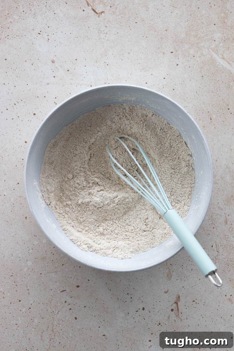 Homemade Baked Cinnamon Sugar Donuts Recipe 4 Dry ingredients mixed together in a bowl with a whisk.