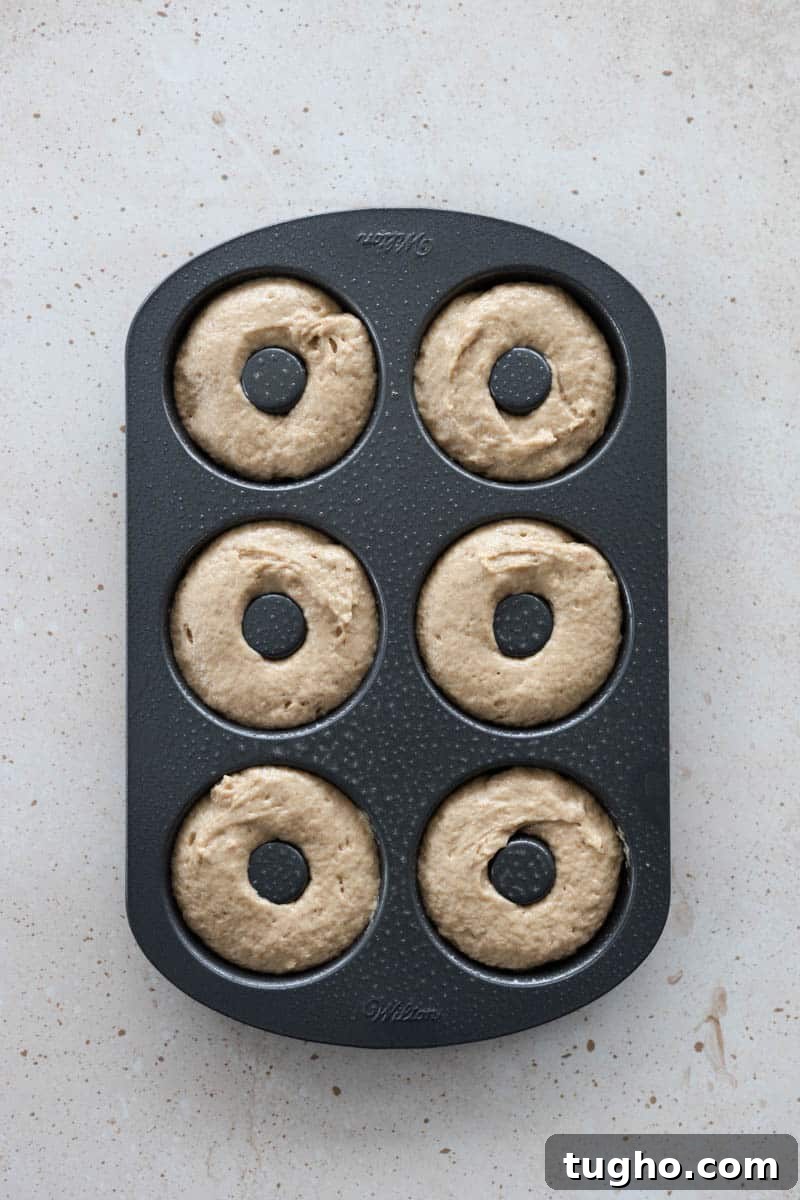 Homemade Baked Cinnamon Sugar Donuts Recipe 8 A 6-hole donut pan filled with batter, ready to bake.
