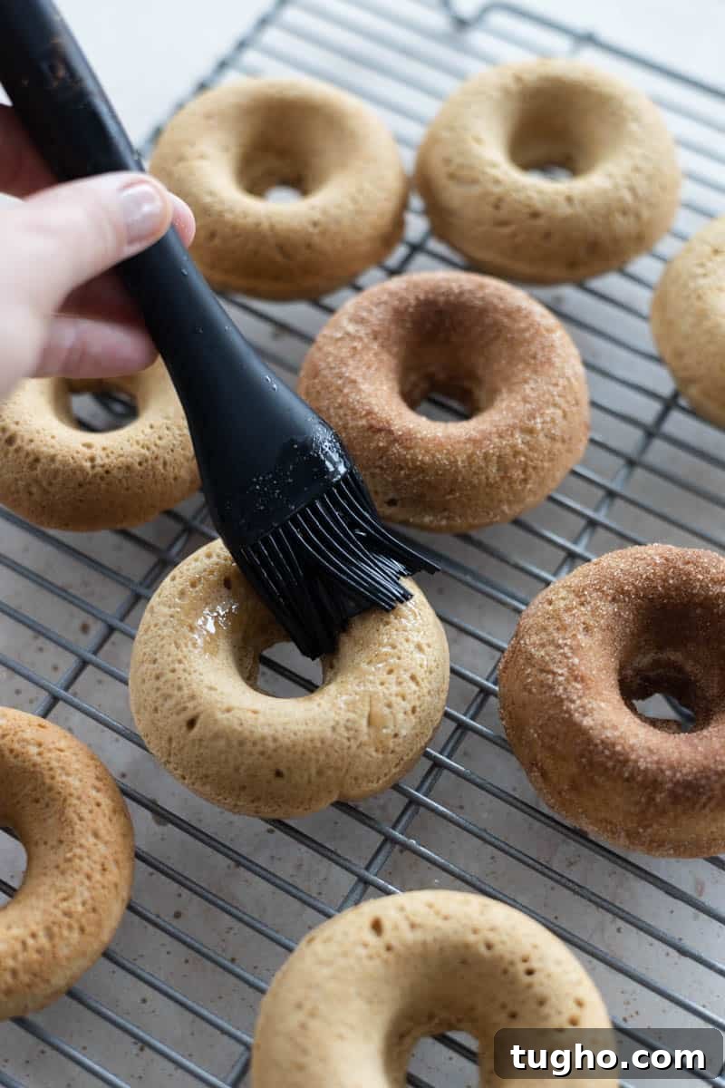 Homemade Baked Cinnamon Sugar Donuts Recipe 9 Brushing the baked donuts with melted butter.