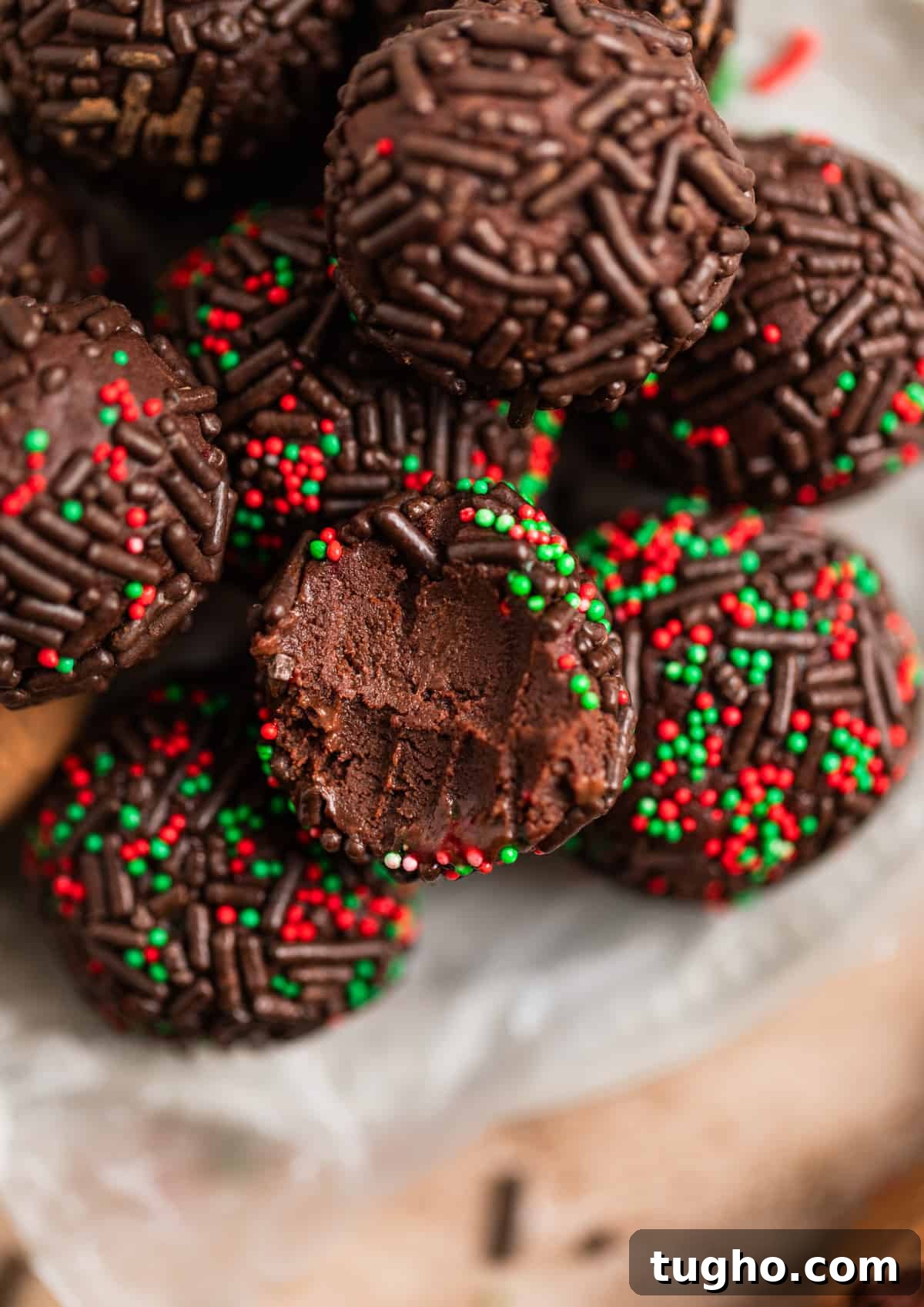 Chocolate, red and green sprinkle covered amaretto truffles arranged on dish.