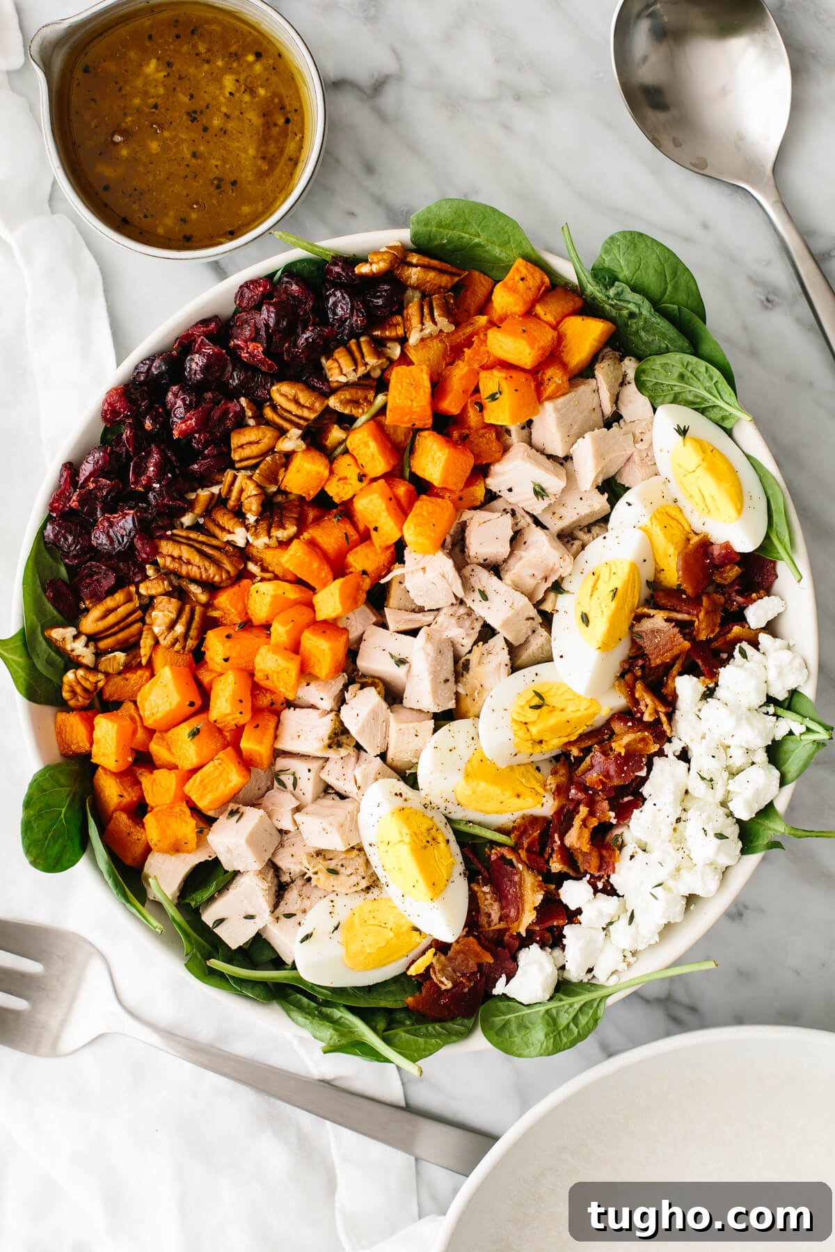 40+ Fresh and Flavorful Salad Recipes 6 Turkey cobb salad in a large bowl on a table next to a spoon.