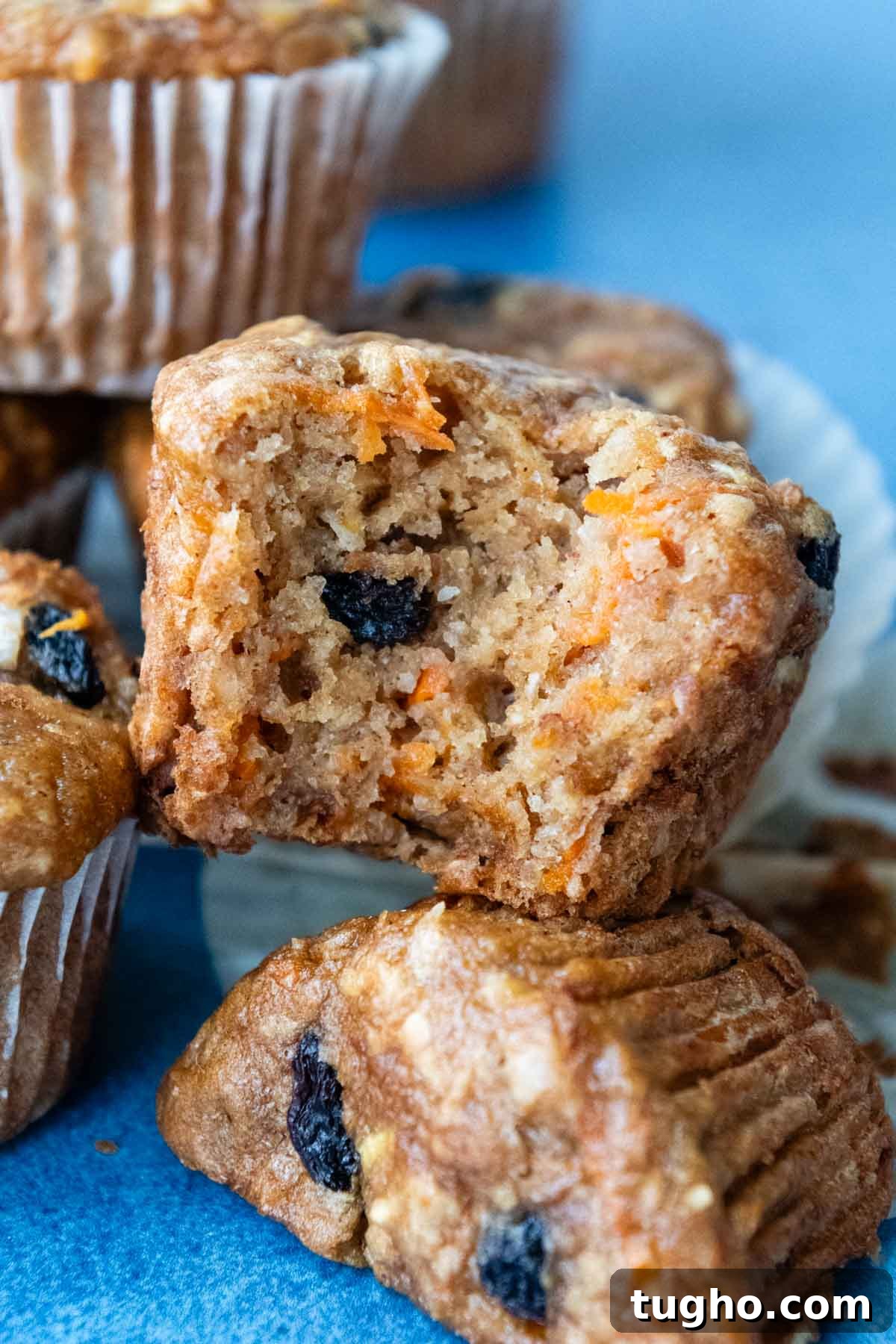 Gluten-Free Morning Glory Muffins: Moist One-Bowl Recipe 8 a bite taken out of a muffin stacked on other muffins.