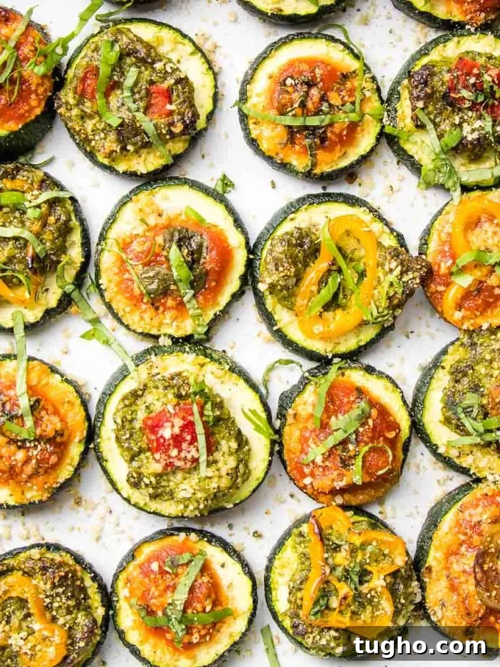Rows of zucchini rounds with pizza toppings.