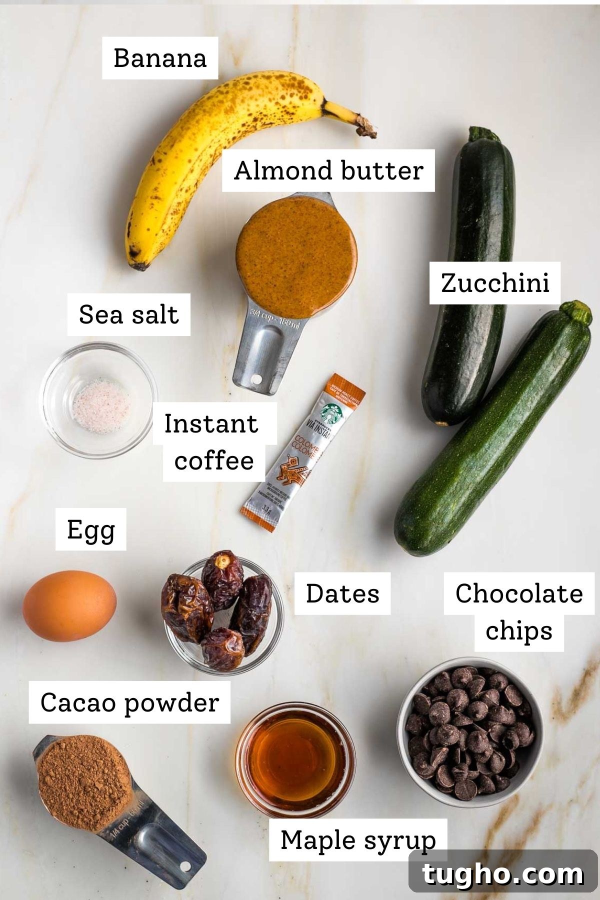 Fudgy Double Chocolate Zucchini Muffins Recipe 4 Labeled ingredients: banana, almond butter, zucchini, salt, egg, dates, maple syrup, cacao, instant coffee and chocolate chips.