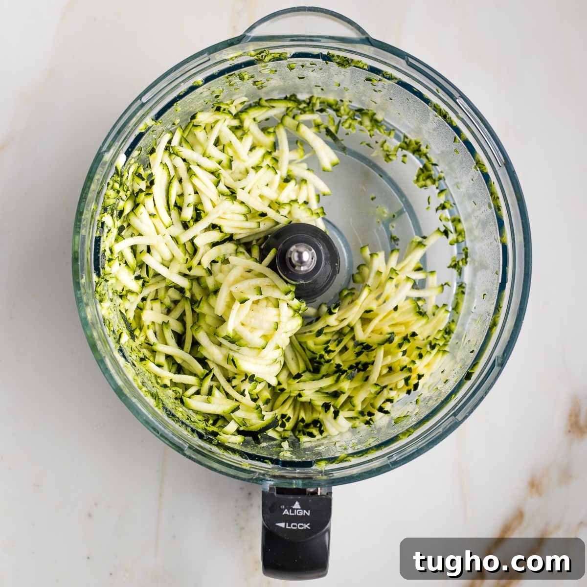 Fudgy Double Chocolate Zucchini Muffins Recipe 5 Shredded zucchini in the bowl of a food processor.