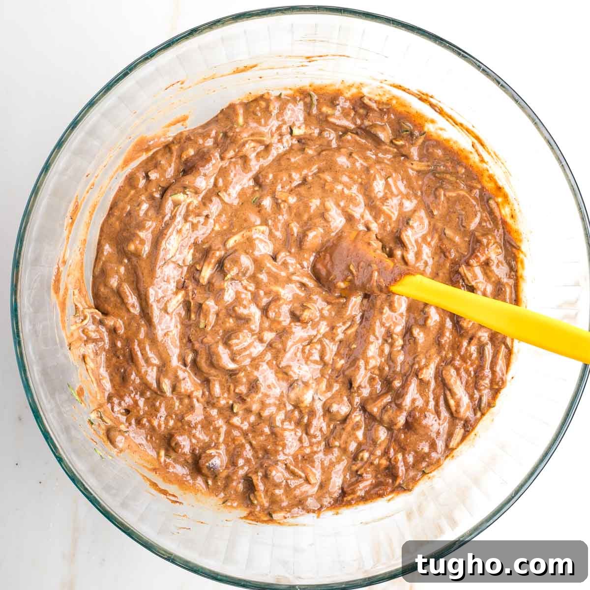 Fudgy Double Chocolate Zucchini Muffins Recipe 9 Chocolate batter in a large bowl with chunks of chocolate and shredded zucchini.