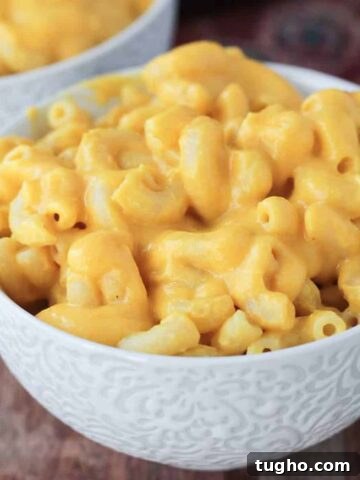 Creamy macaroni and cheese in a white bowl.
