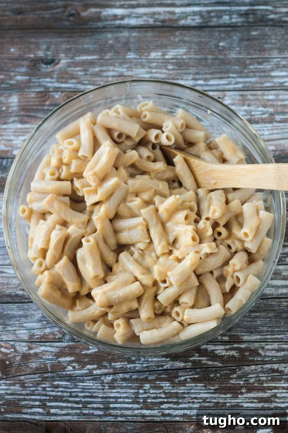 Ziti noodles and vegan white sauce mixed in a bowl.