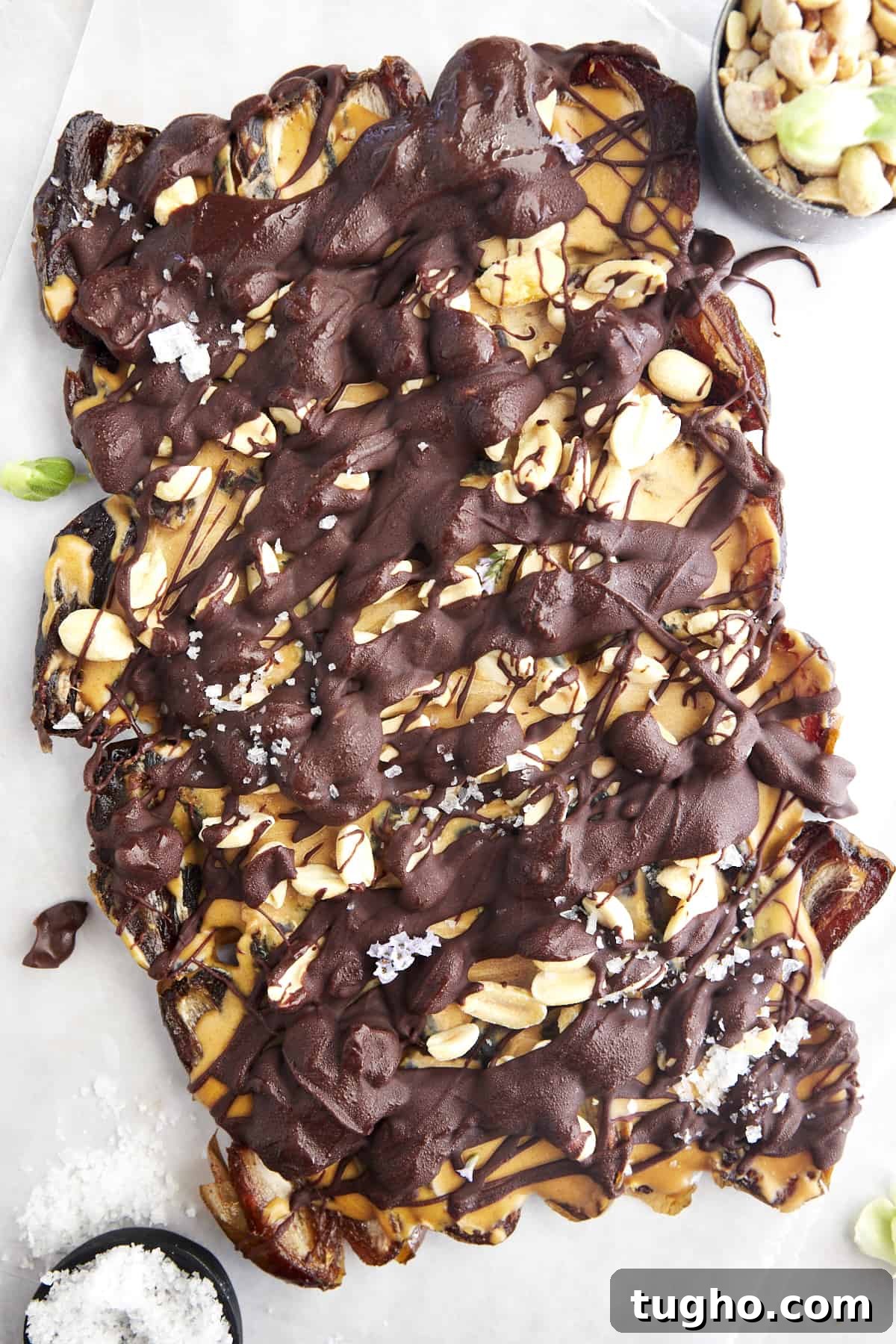 Viral TikTok Date Bark Recipe: Chocolate and Nuts 2 A slab of Snickers date bark topped with sea salt.