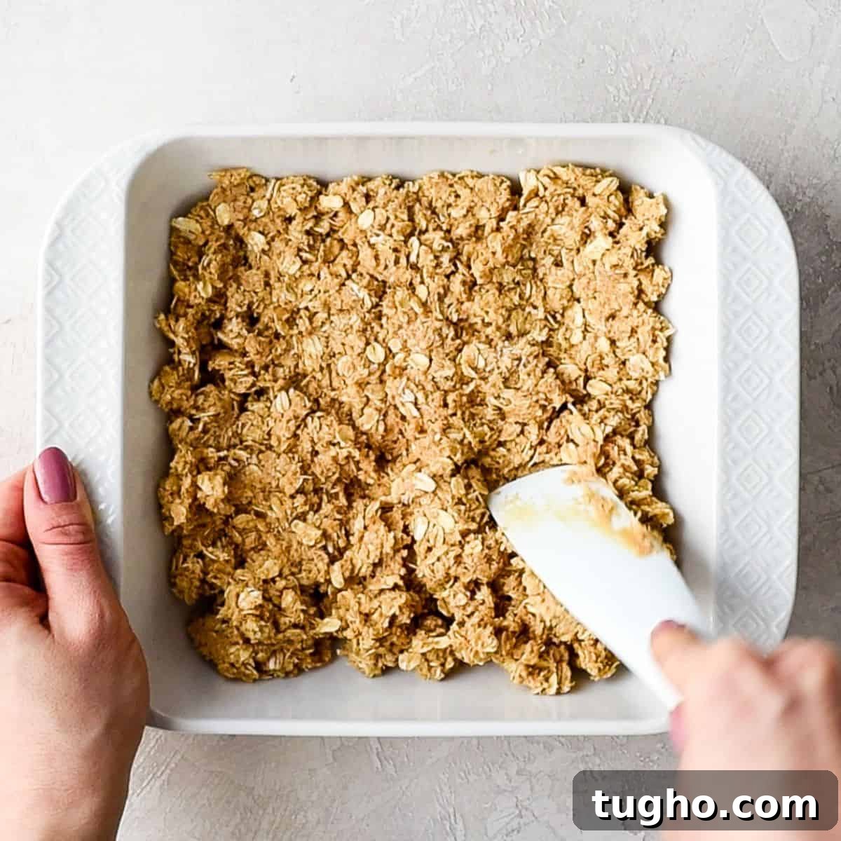 Chewy No-Bake Oatmeal Bars Recipe 8 No Bake Oatmeal Bars being pressed into a baking dish