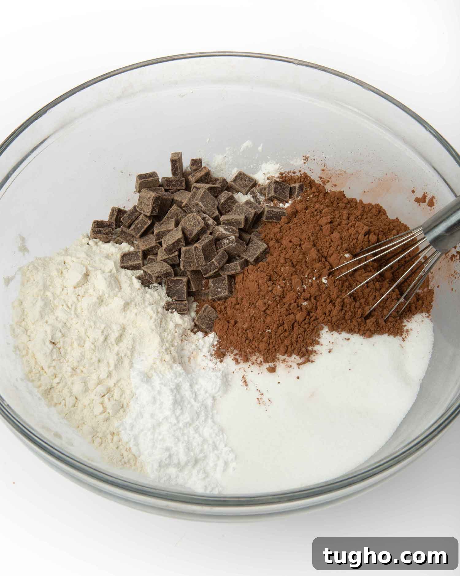 Homemade Brownie Mix Recipe for Gifts 6 Dry brownie mix ingredients in a glass bowl including flour, cocoa powder, and dark chocolate chunks with a whisk