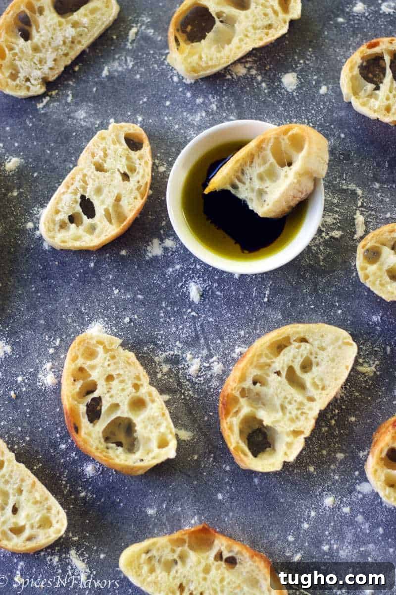 How to Make Authentic Ciabatta Bread at Home 8 slices of ciabatta bread placed around a white bowl filled with olive oil