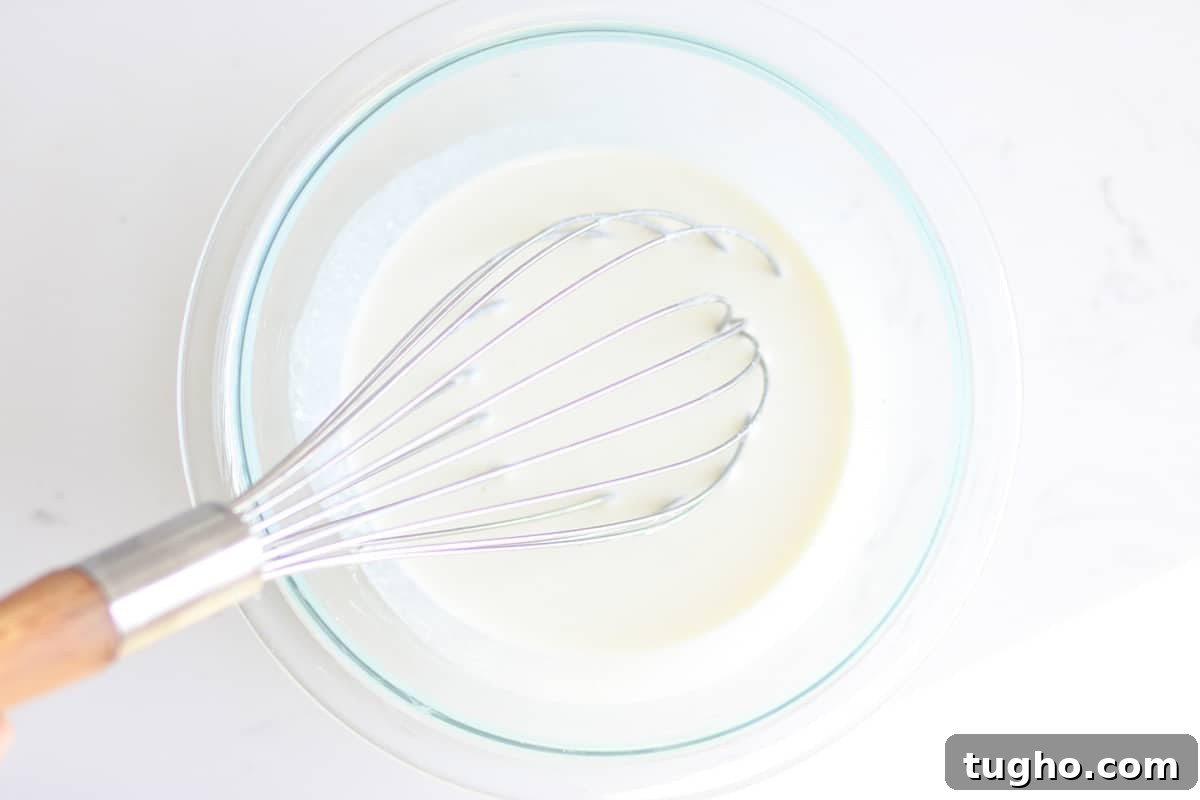 a whisk in a bowl of liquid homemade deodorant 