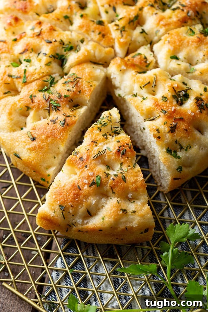 No-Knead Herbed Focaccia with Rosemary and Sea Salt 5 Round herbed focaccia loaf with a wedge removed