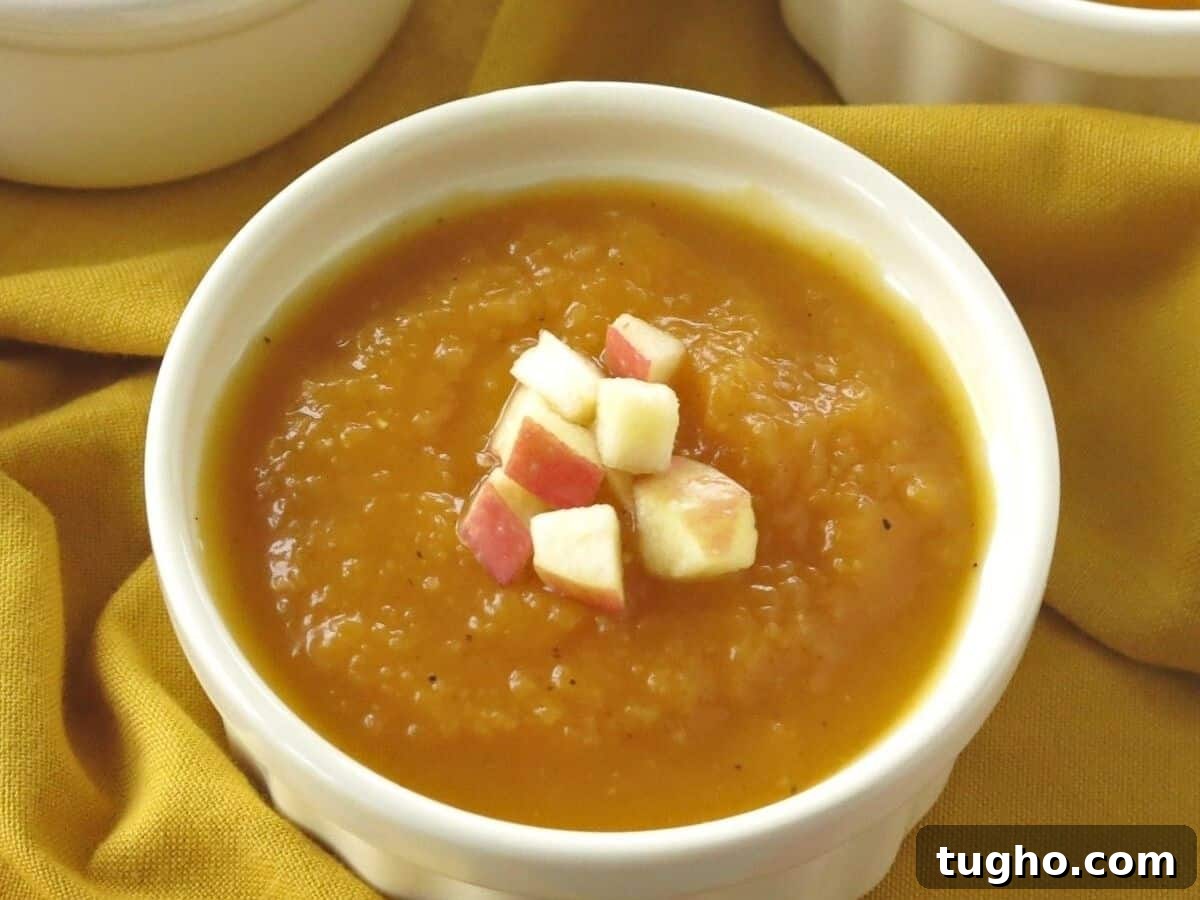 15 Make-Ahead Thanksgiving Recipes to Prep Now 11 Bowl of butternut squash apple soup with diced apples on top.