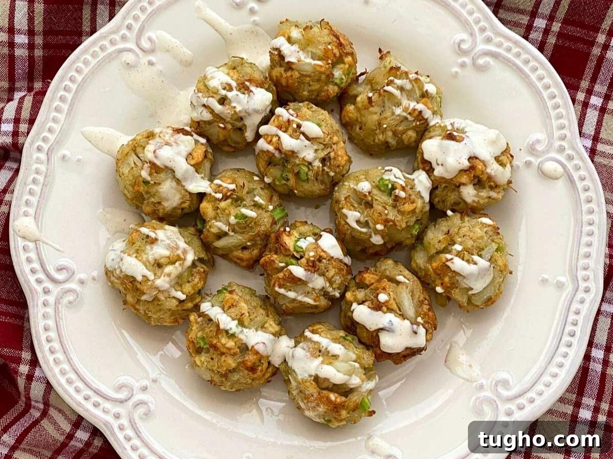 15 Make-Ahead Thanksgiving Recipes to Prep Now 15 Fourteen crab balls on a white plate with aioli drizzled on top.