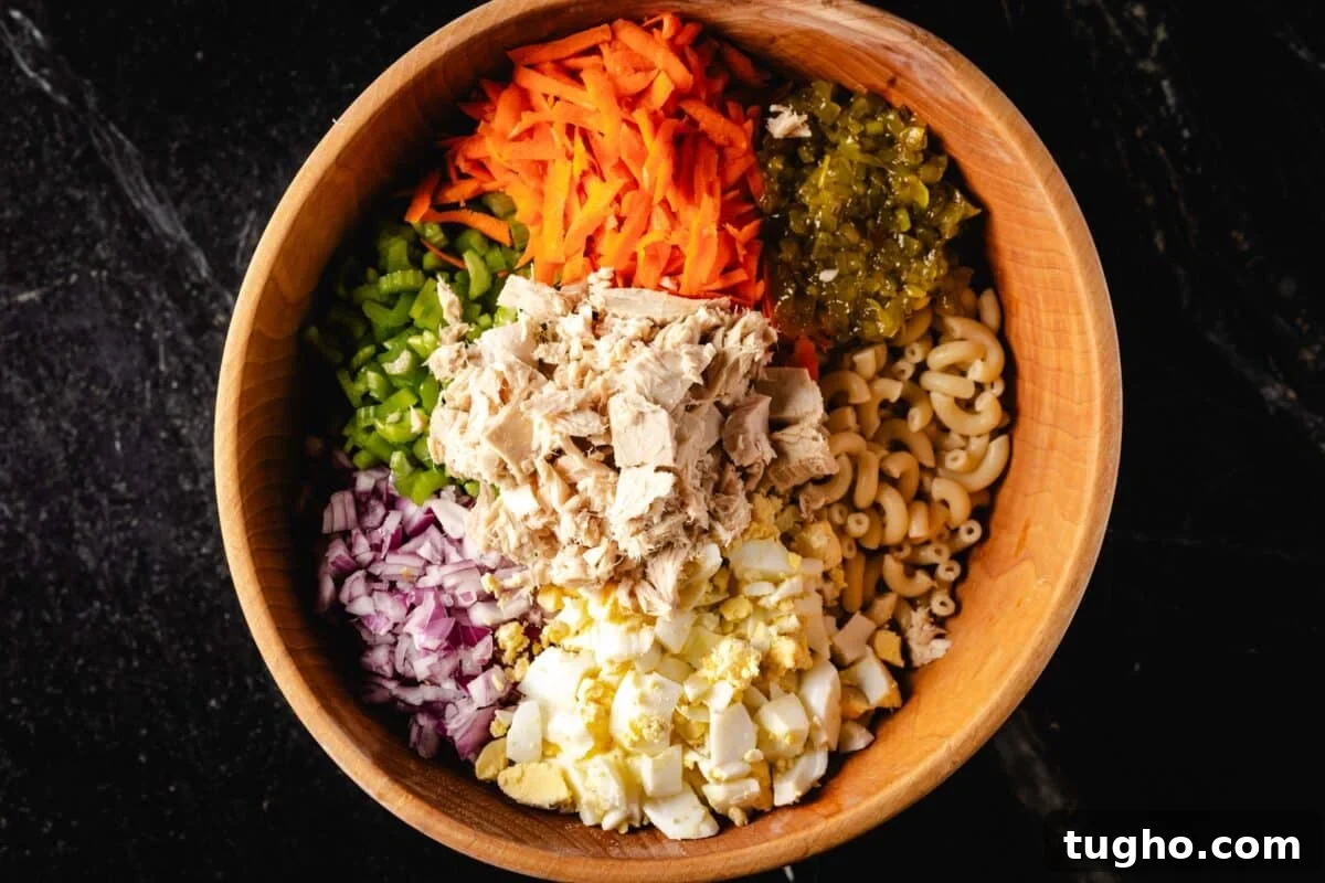 Tuna Macaroni Salad with Zesty Homemade Dressing Recipe 5 Tuna, macaroni noodles, and chopped veggies in a wooden salad bowl.