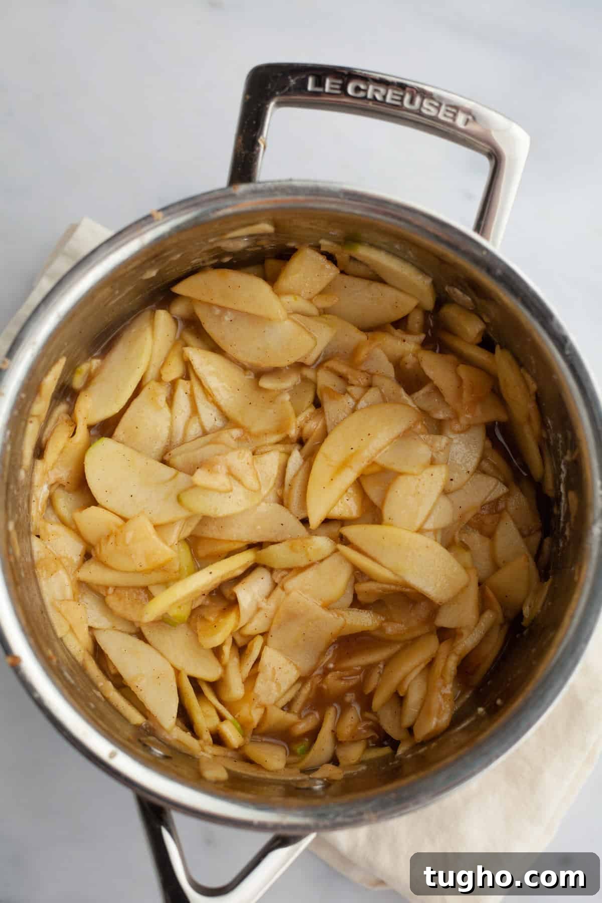 A silver saucepan with apple pie filling in it