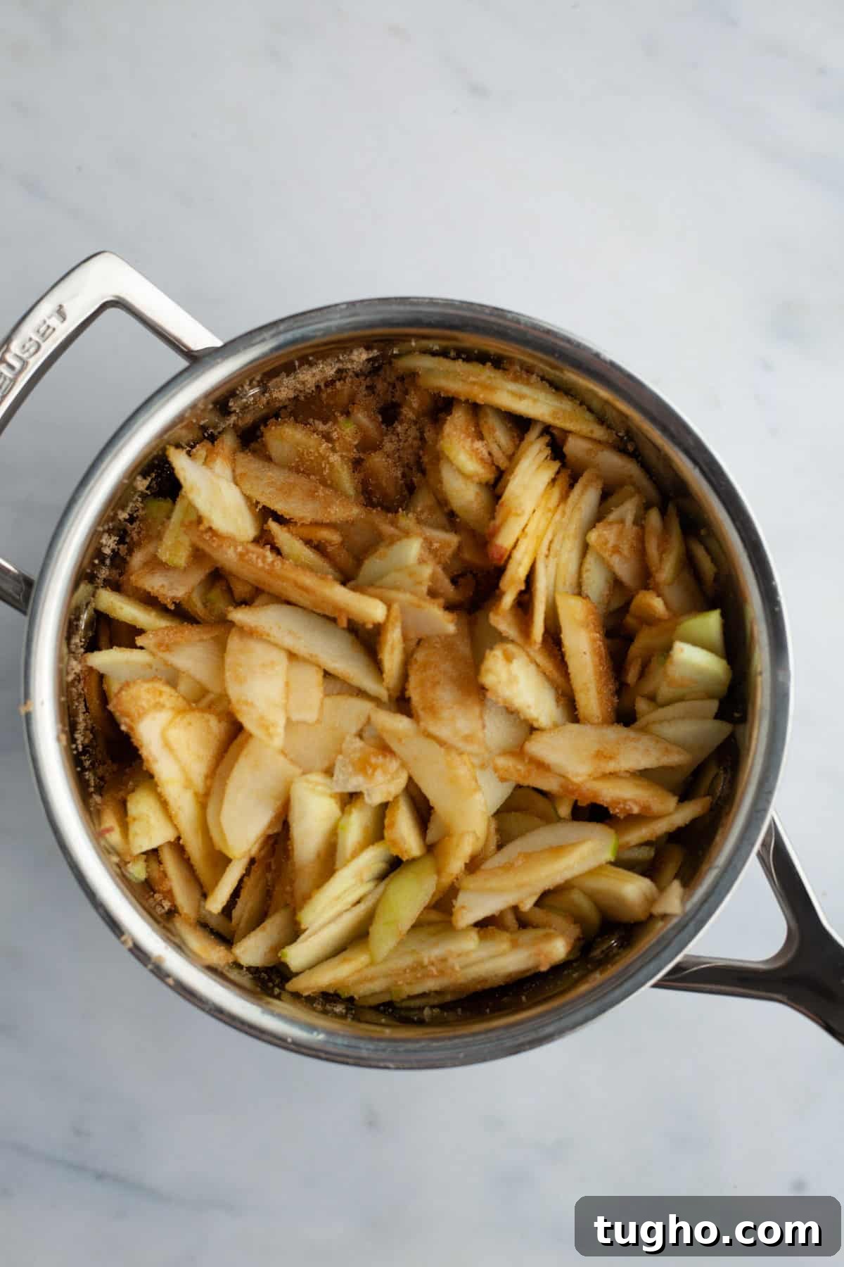 slices of apple tossed in cinnamon in a small saucepan