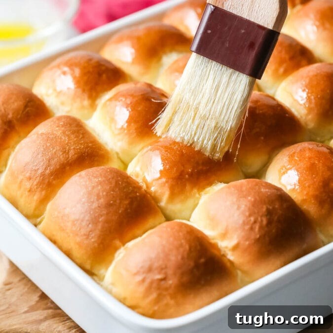 Melted butter being brushed onto make ahead dinner rolls.