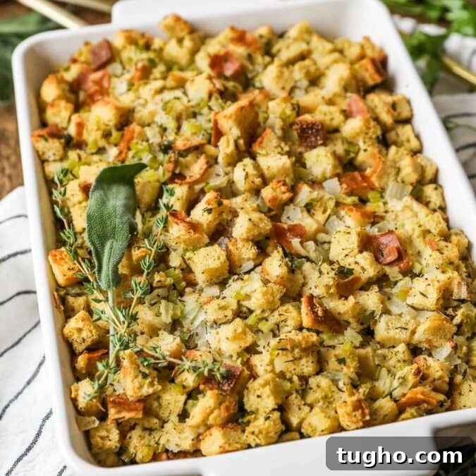 Overhead view of a casserole dish of stuffing topped with a bundle of fresh herbs.