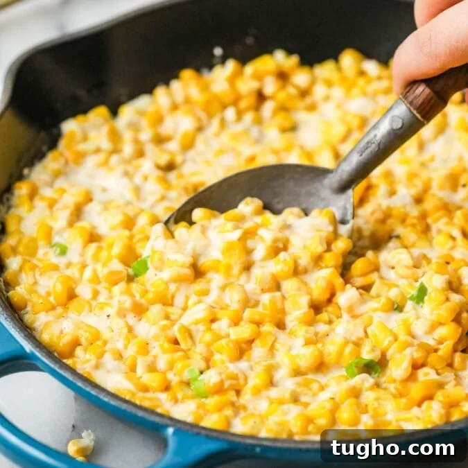 Spoon scooping creamed corn out of a skillet.