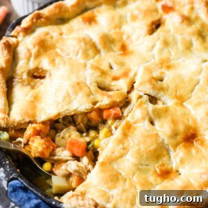 Close-up view of a turkey pot pie with one slice missing.