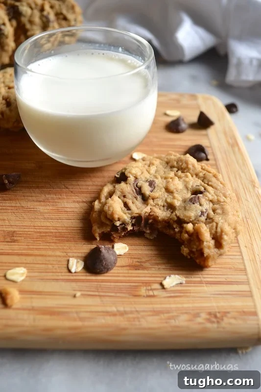 Chewy Oatmeal Peanut Butter Chocolate Chip Cookies Recipe 4 cookie with a bite missing and a cup of milk