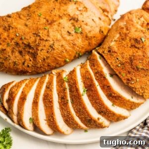 Juicy baked turkey breasts with crispy seasoned coating, sliced and garnished with fresh herbs.