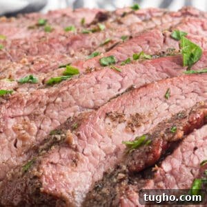 Sliced beef on a plate with herbs and spices.