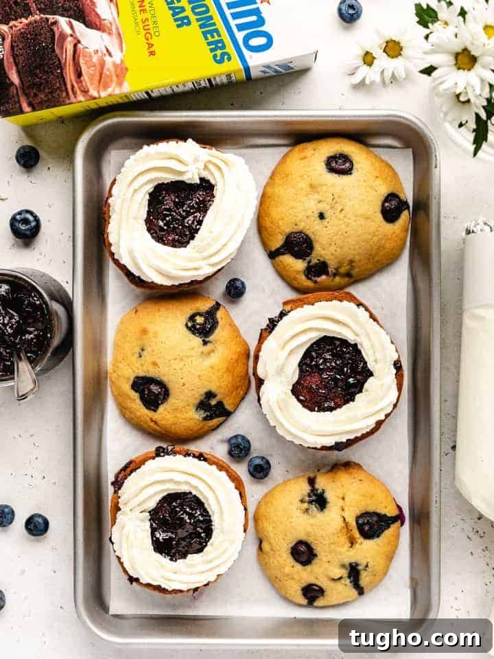 Blueberry Whoopie Pies Recipe: Soft Cream-Filled Treats 10 blueberry whoopee pies getting assembled with whipped cream and blueberry jam filling