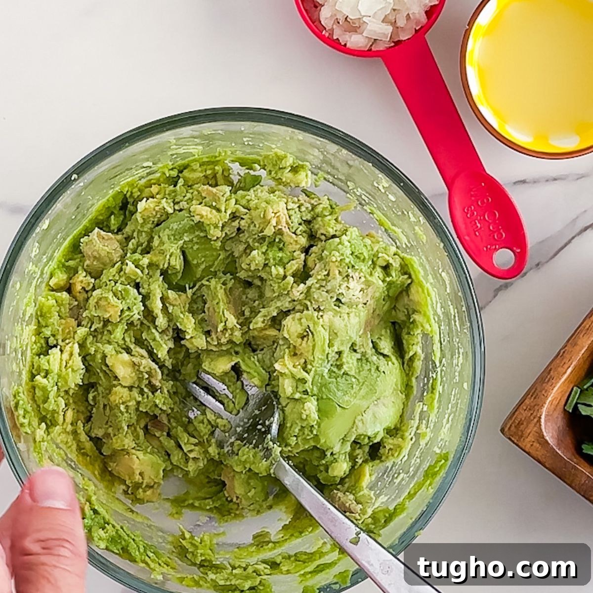 How to Make Authentic Mexican Guacamole with Lime and Cilantro 4 Mixing the guacamole.