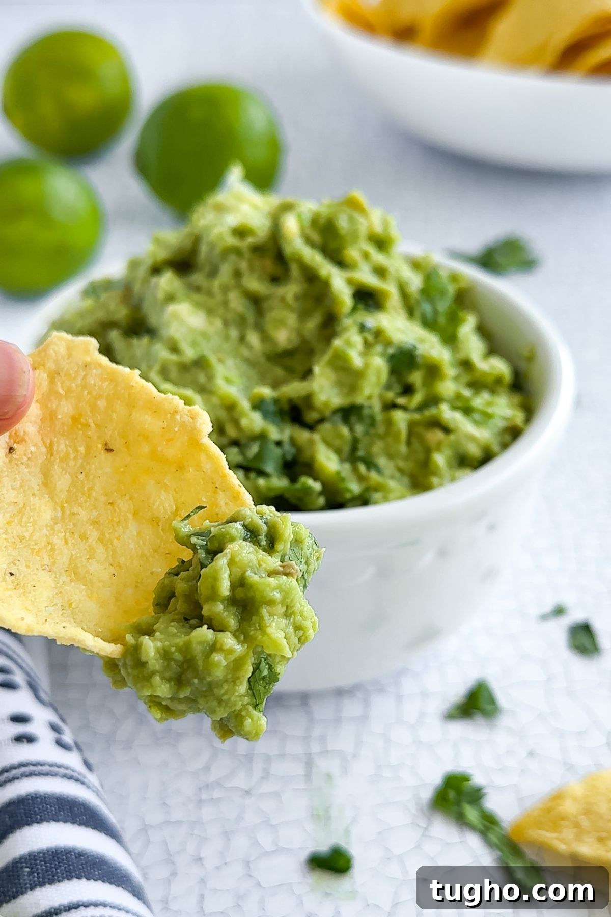 How to Make Authentic Mexican Guacamole with Lime and Cilantro 7 Dipping a chip in guacamole.