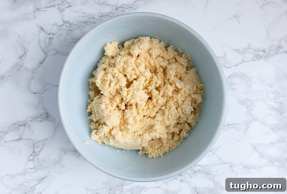 Keto Cornbread Muffins - Low-Carb, Fluffy & Savory 4 keto cornbread batter sitting in a bowl on a marble countertop