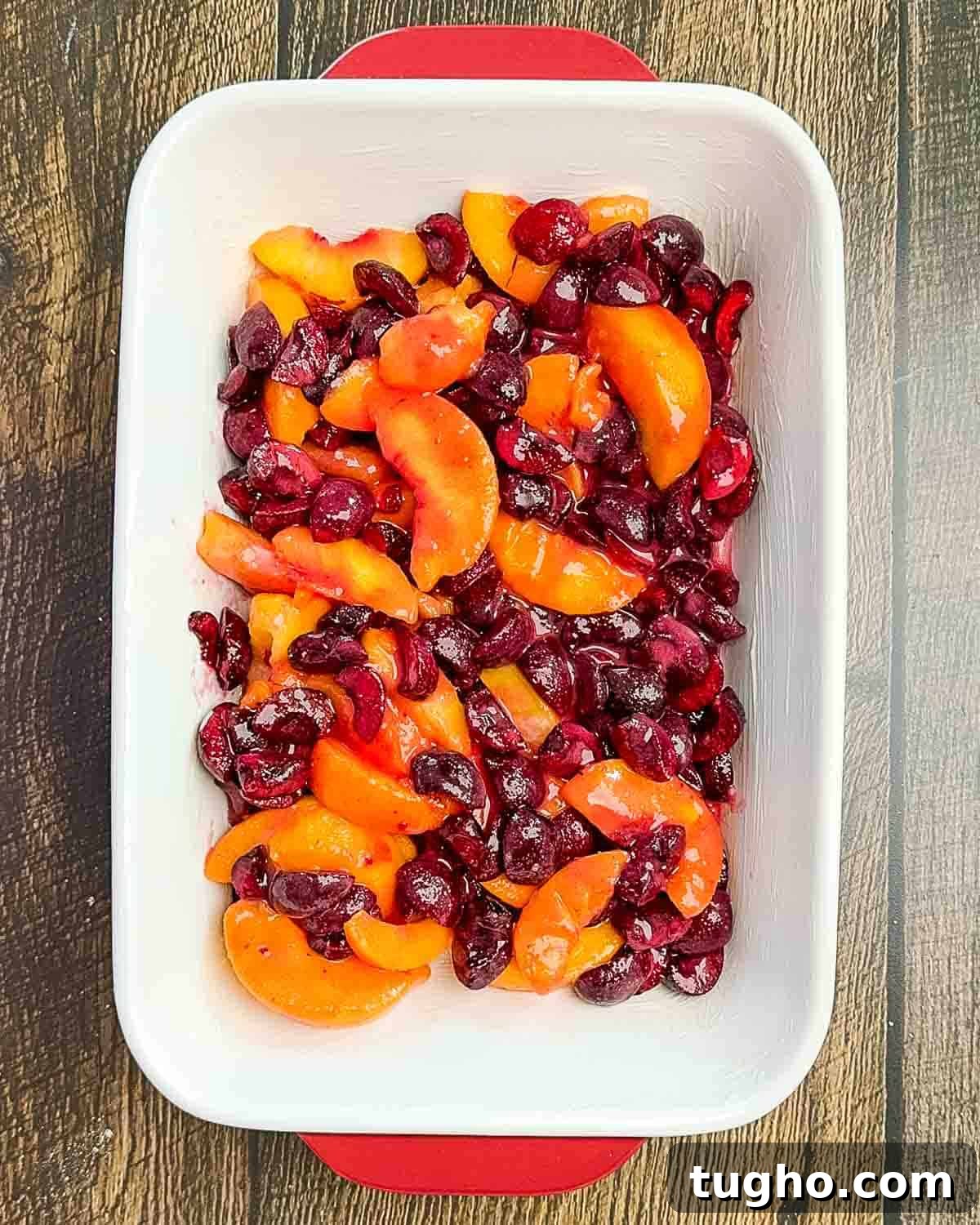 Homemade Cherry and Peach Cobbler Recipe 7 The fruit mixture in a baking dish.