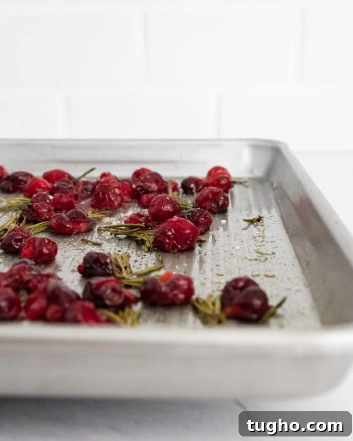 Baked Brie with Roasted Cranberries: Warm Appetizer 5 Sheet pan filled with roasted cranberries and fresh rosemary