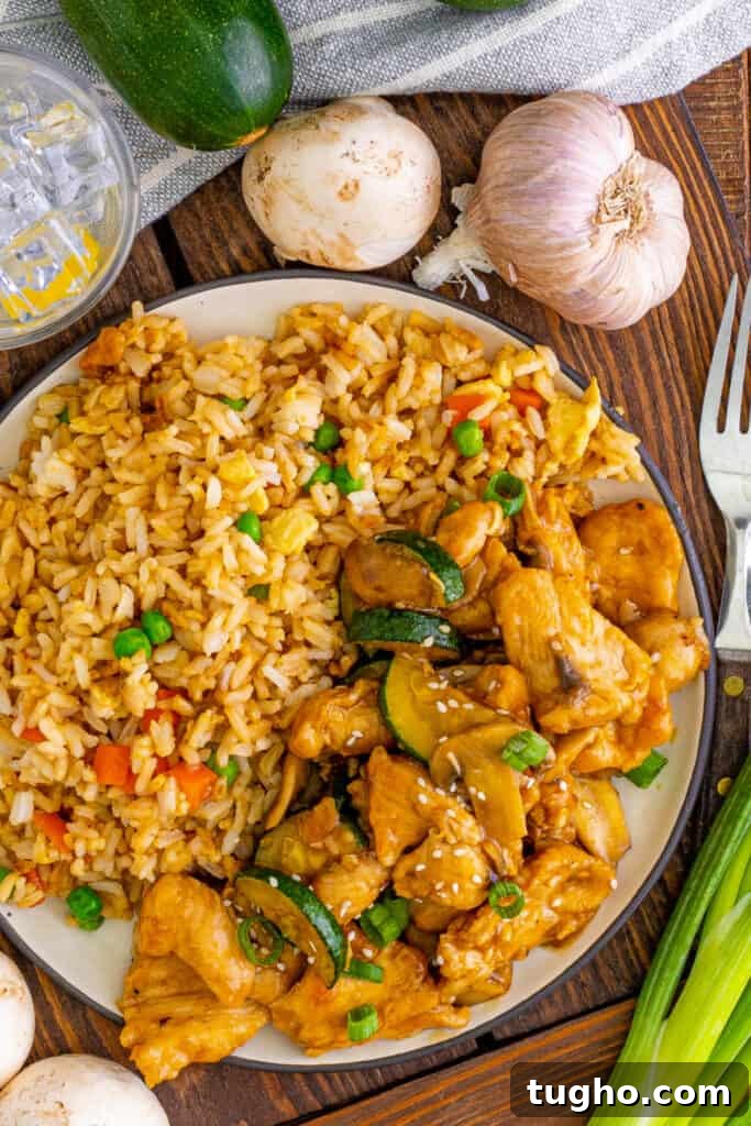 looking down onto a plate with fried rice and copycat panda express mushroom chicken