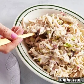 Scooping Chicken Salad out of bowl with fork.