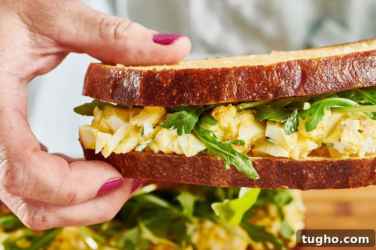30 No-Cook Summer Recipes for Cool, Refreshing Meals 3 Woman holding an Egg Salad sandwich.