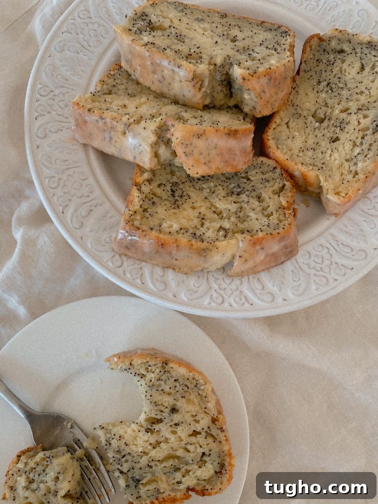 Moist Gluten-Free Lemon Loaf Recipe 3 Sliced Lemon Poppyseed Loaf with glaze on white glass plate
