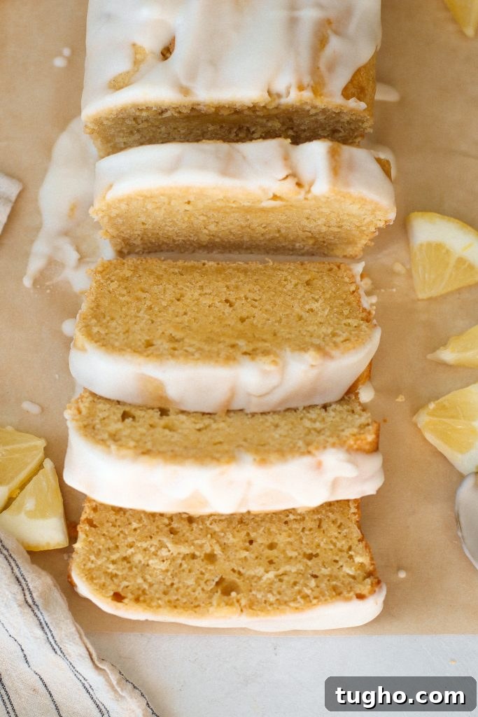 Moist Gluten-Free Lemon Loaf Recipe 4 Gluten free lemon loaf with lemon glaze on parchment paper with slices of lemon