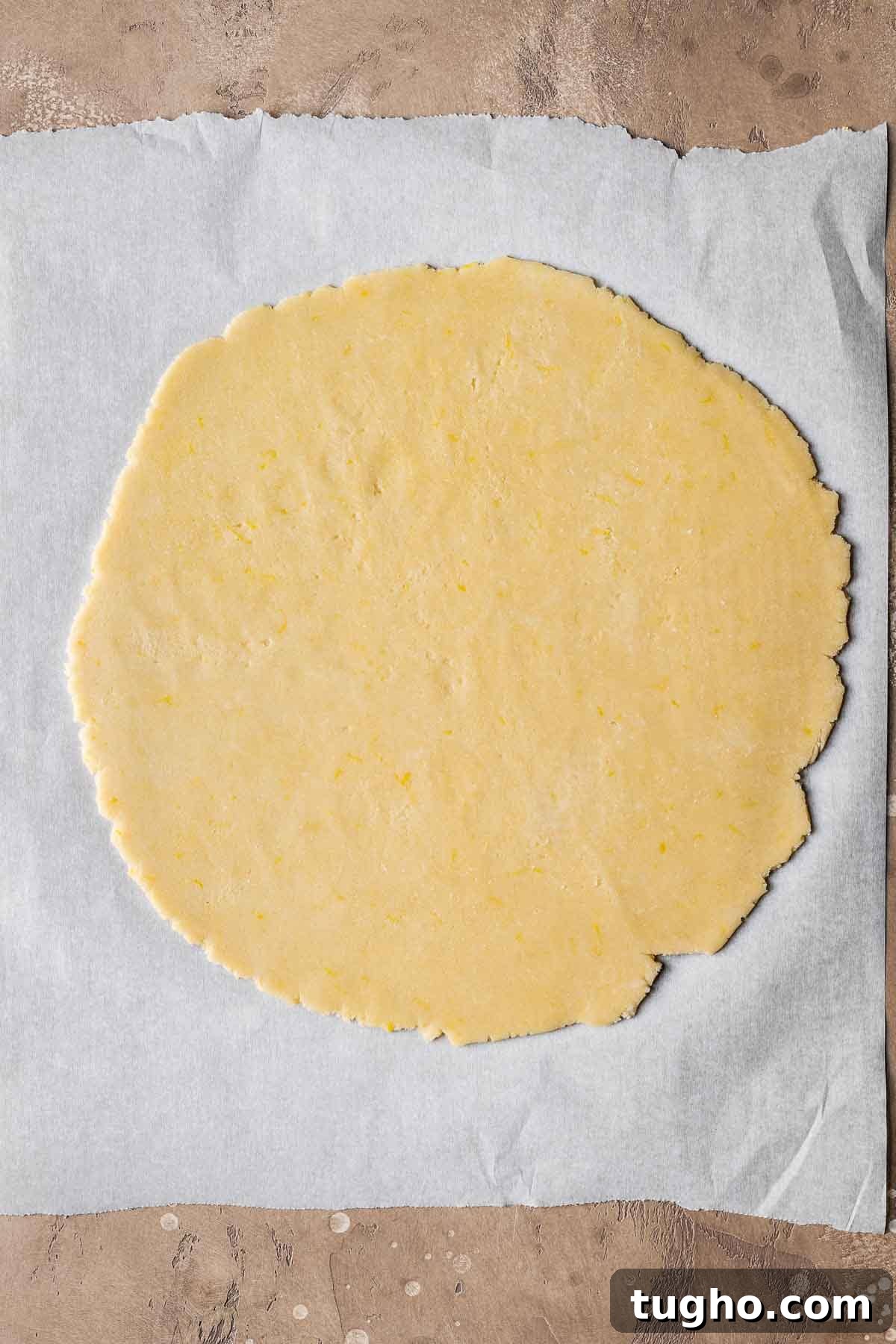 Classic Italian Jam Crostata Recipe 8 A circle of rolled pastry dough on white parchment paper.