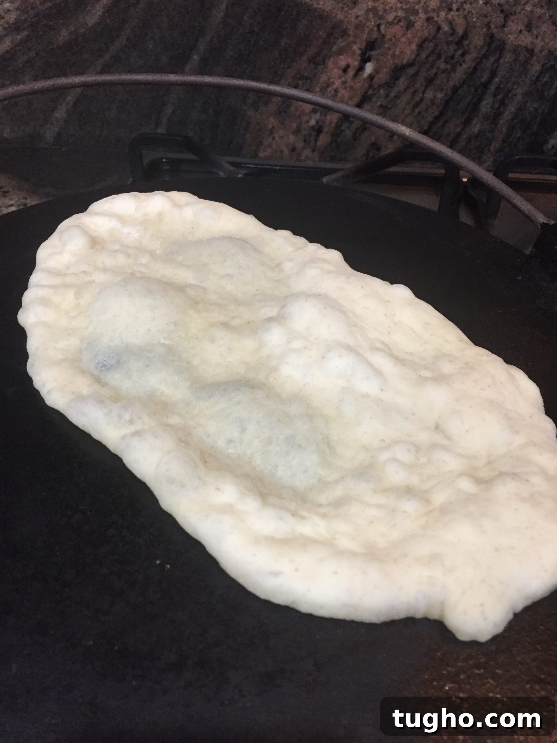 Naan on griddle Naan cooking on griddle