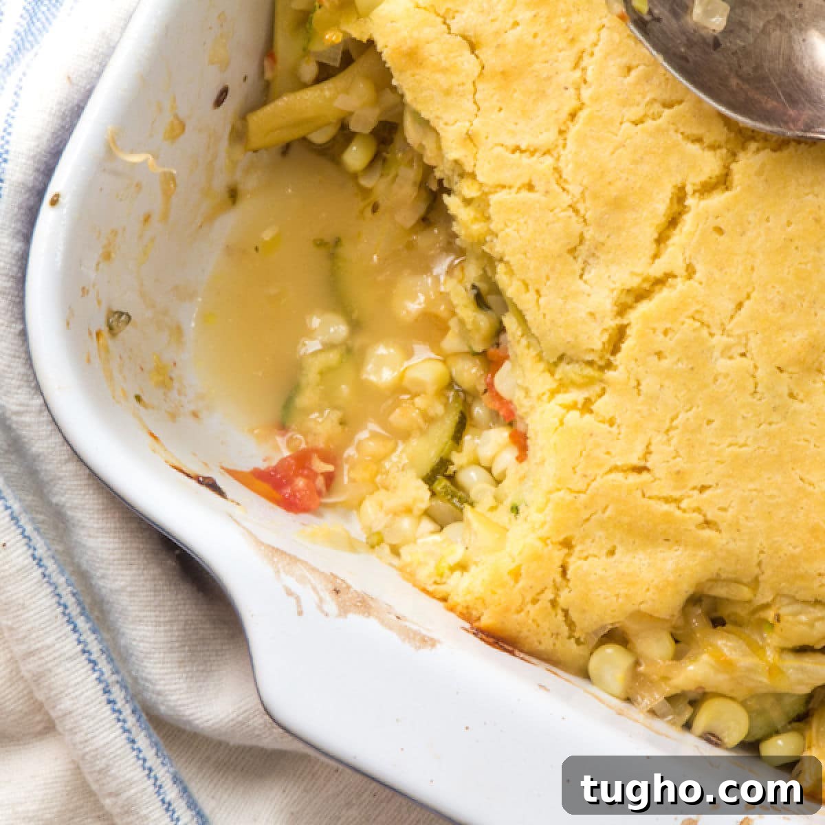 Zucchini Cobbler with Golden Cornbread Topping Recipe 2 Zucchini, corn and bean casserole topped with cornbread, with a scooped out portion.