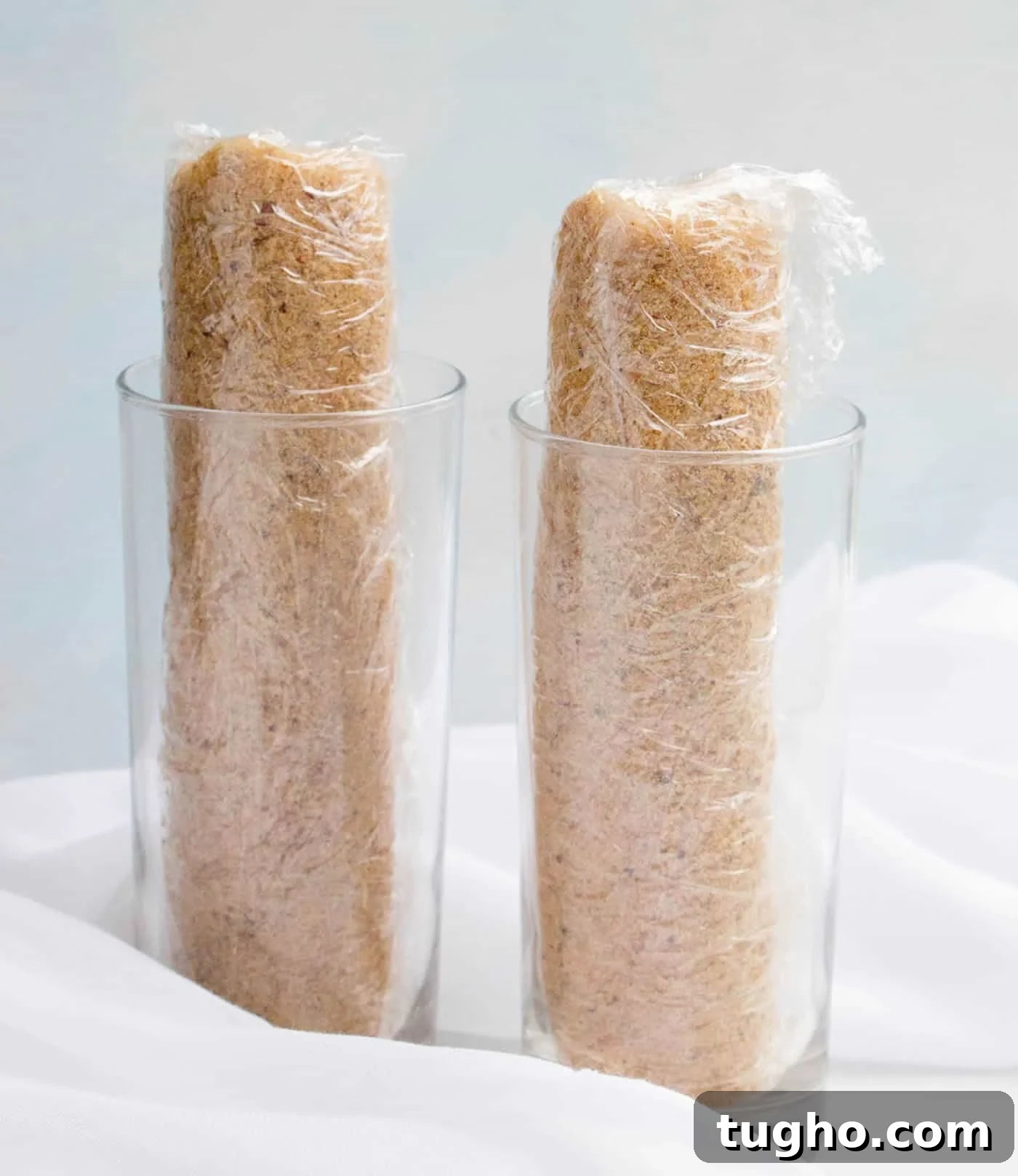 How to Make Slice-and-Bake Cheesecake Cookies 7 Two loaves of Slice and Bake Cheesecake Cookies wrapped and standing in glasses