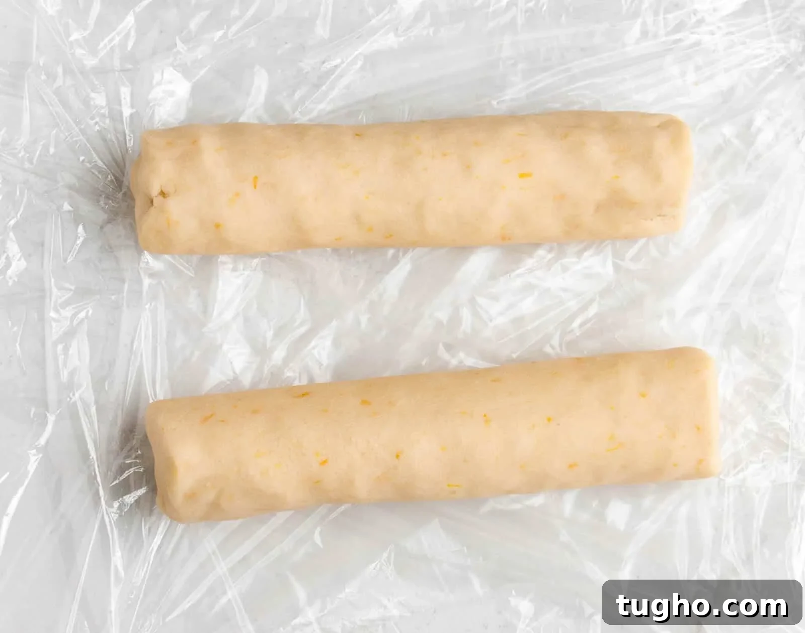 How to Make Slice-and-Bake Cheesecake Cookies 4 Two rolls of uncooked Slice and Bake Cheesecake Cookies on cello-fain