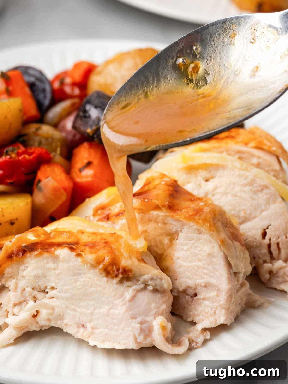Crispy Oven Roasted Lemon Chicken with Garlic and Herbs 2 adding pan sauce to sliced chicken.