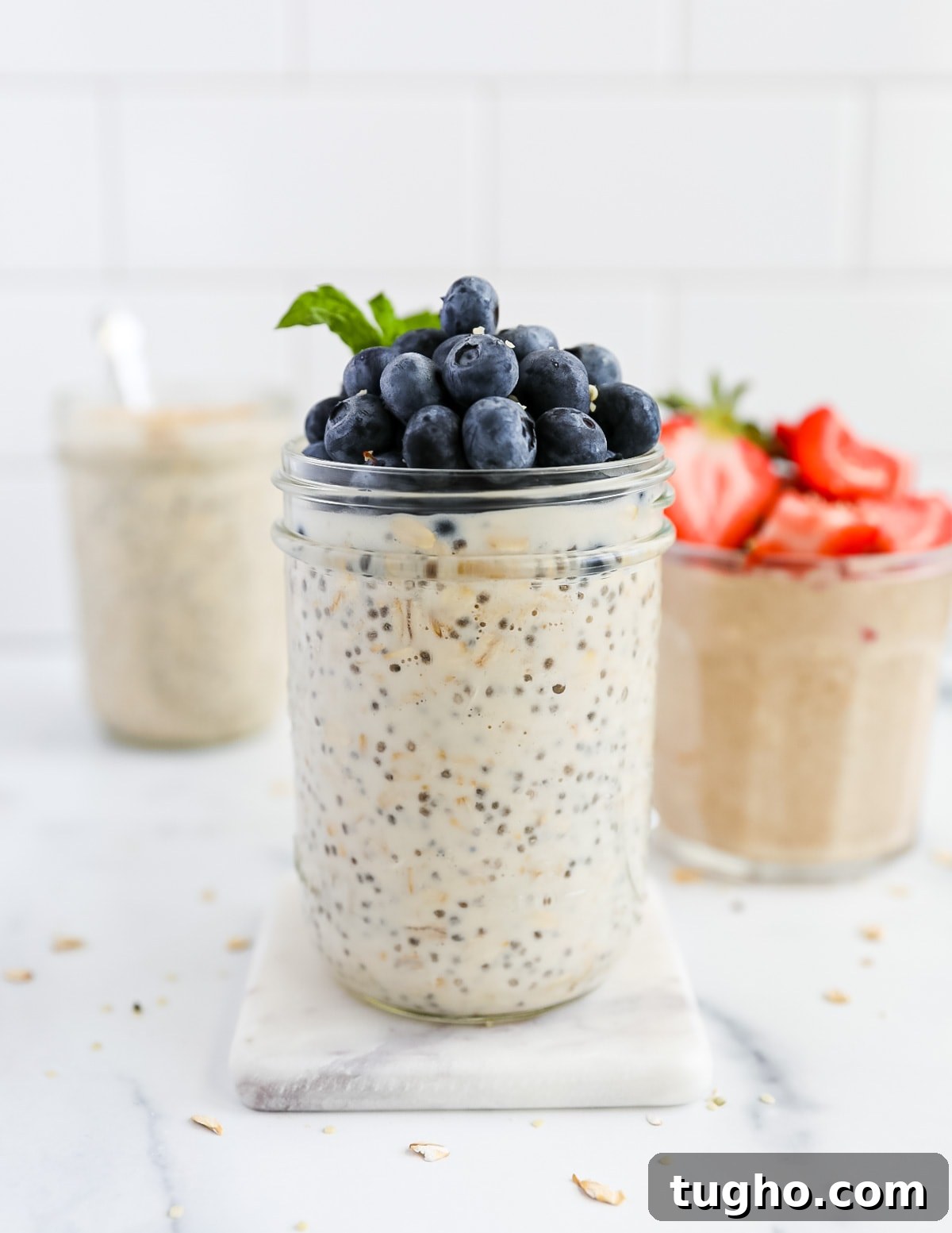 Three jars of overnight oats topped with fresh berries